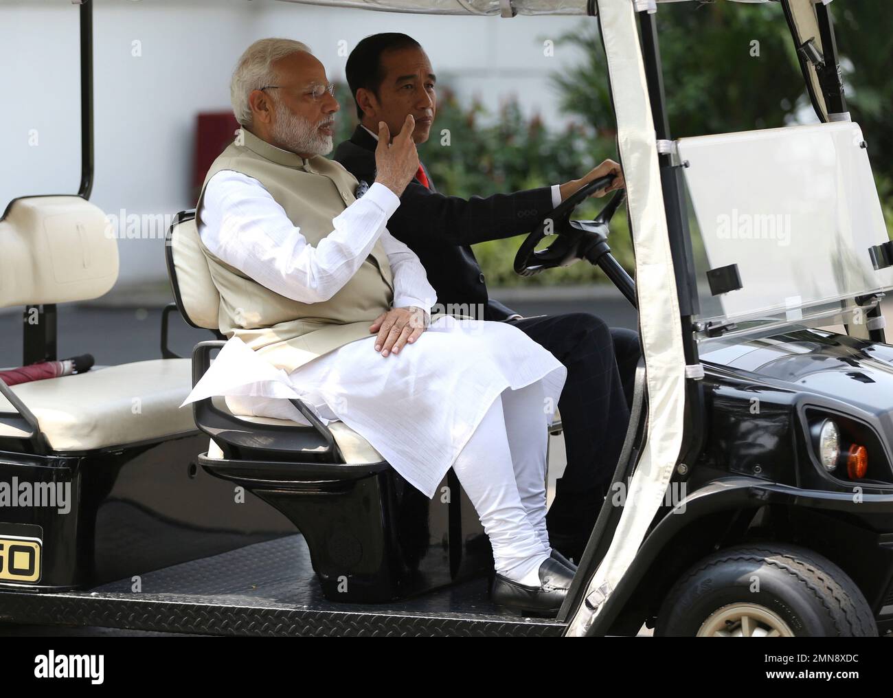 Indian Prime Minister Narendra Modi, left, rides on a golf cart driven ...
