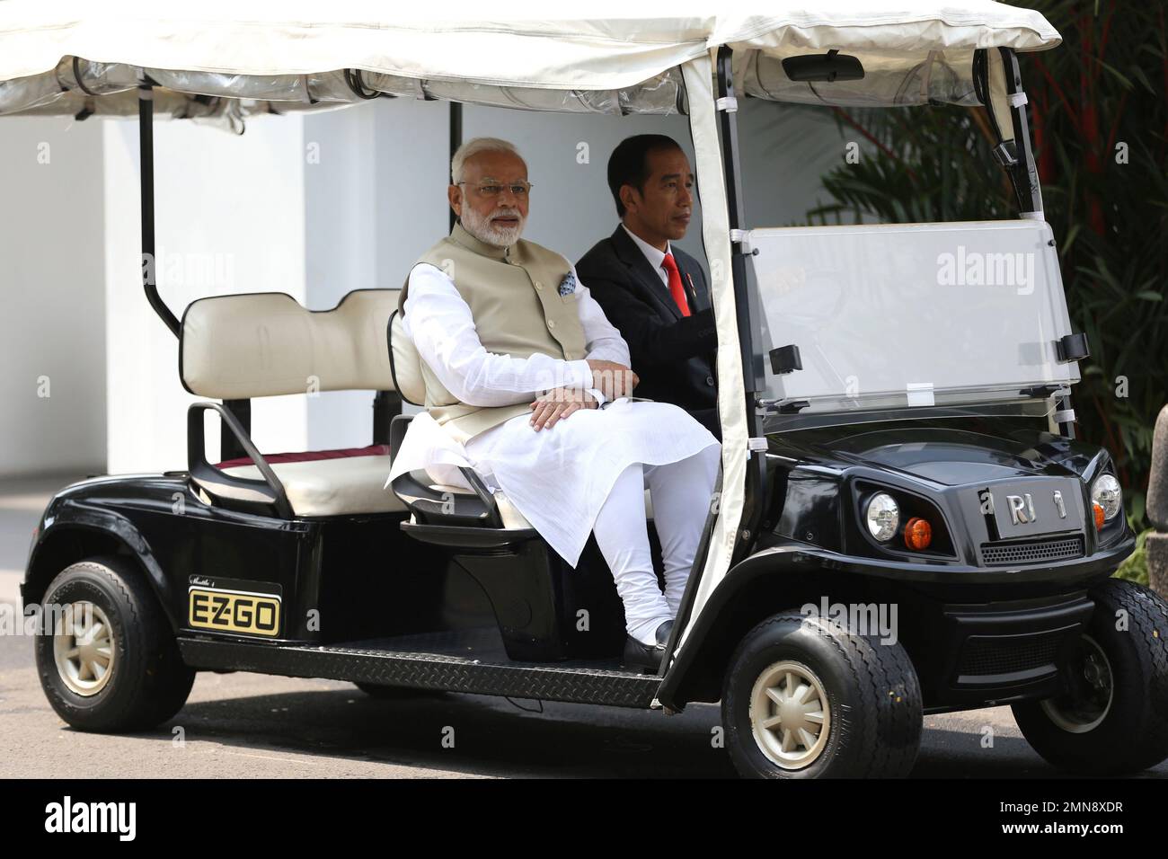 Indian Prime Minister Narendra Modi, left, rides on a golf cart driven ...