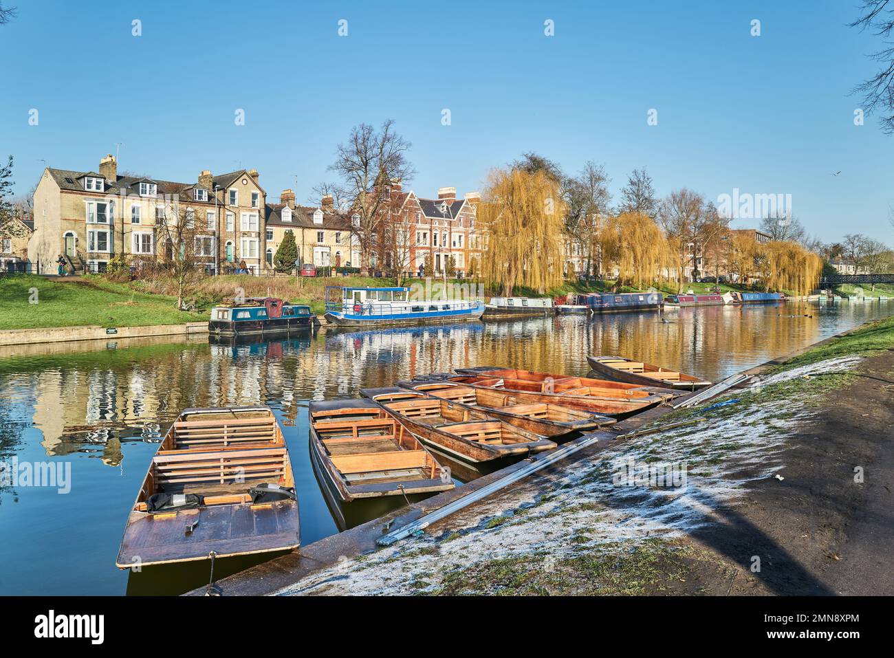 Punts moored to the bank of the river Cam, Cambridge, England, on a sunny winter day. Stock Photo