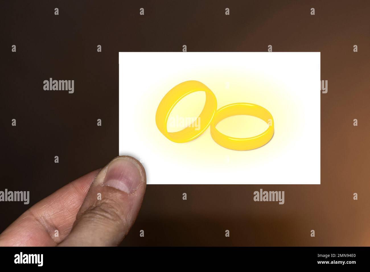 Hand holding card decorated with golden rings Stock Photo - Alamy