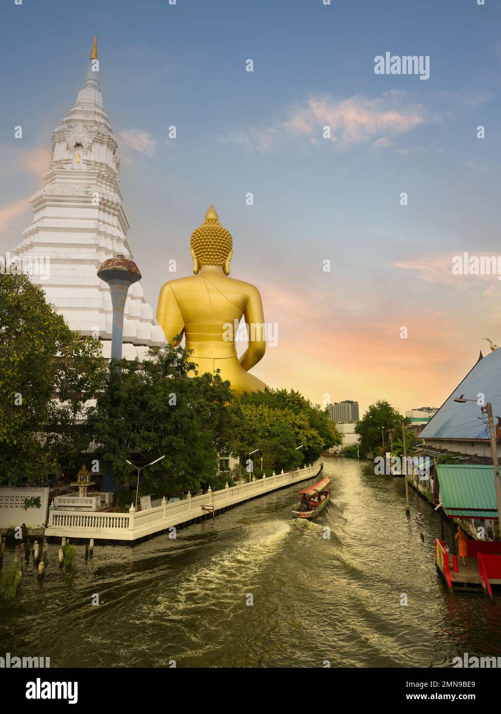Big Buddha (Wat Paknam) at sunset time. Chao Phraya river canal cruise. Tourists traveling by traditional boats. Thailand's most important travel dest Stock Photo