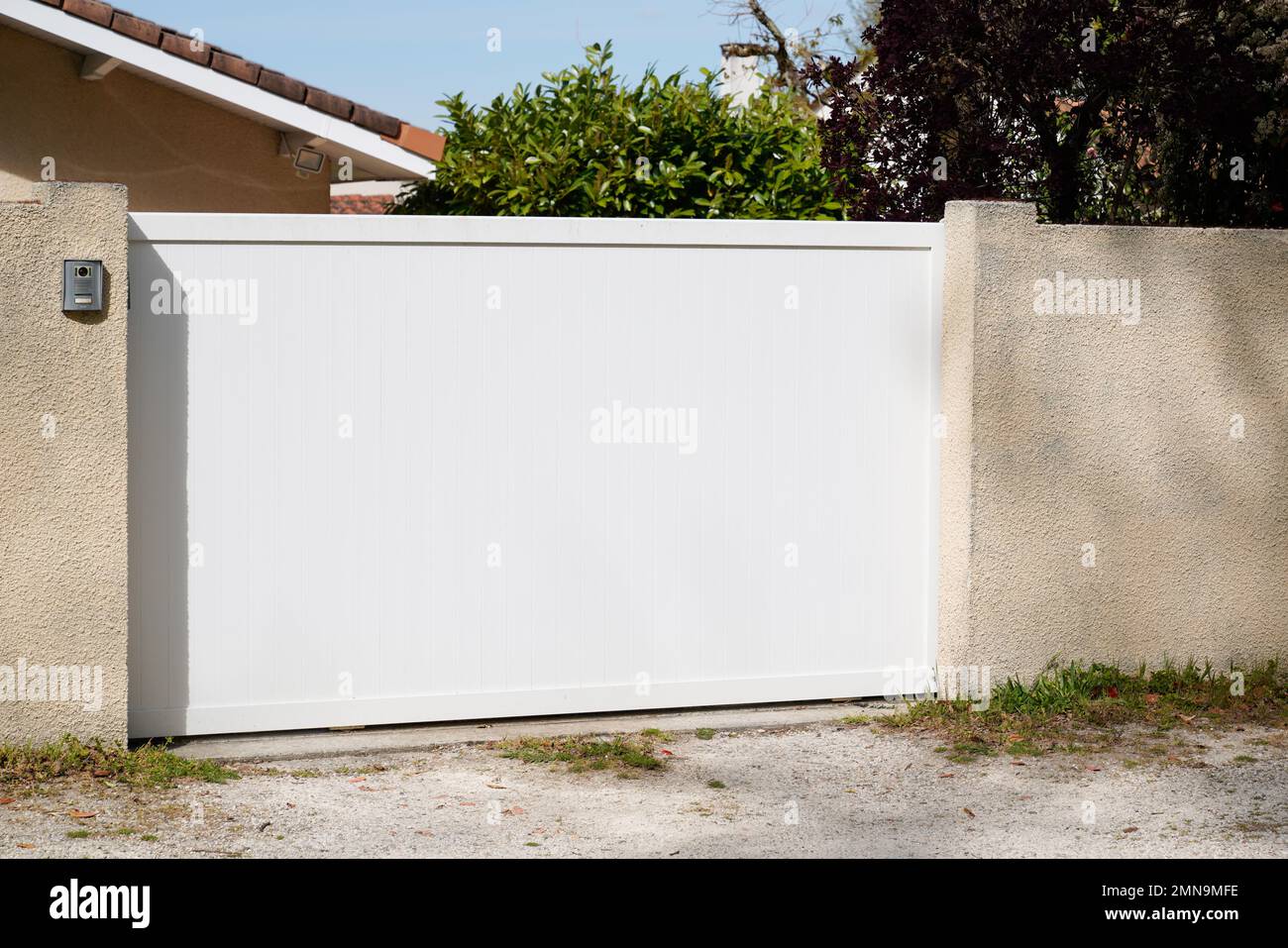 portal sliding white steel garden gate in front of suburb family home Stock Photo