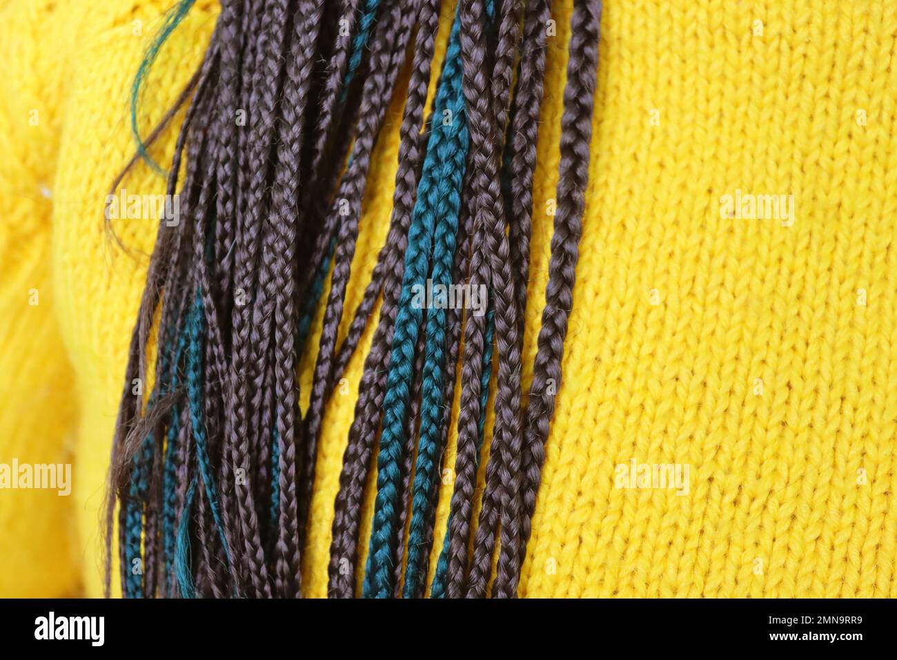 Girl with dreadlocks in a yellow sweater. Close up view Stock Photo