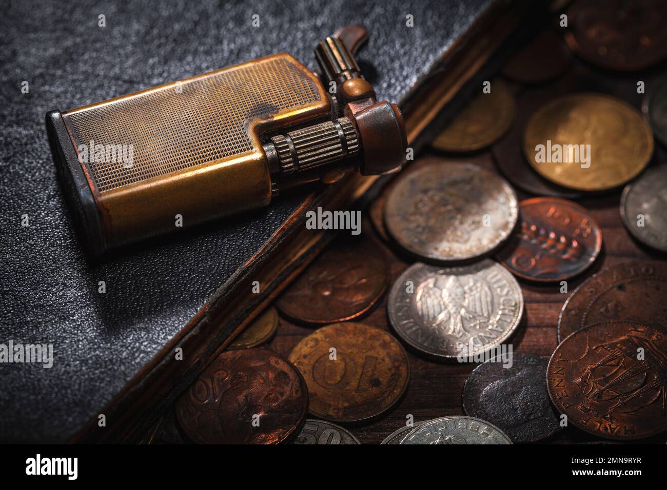 Old coins from around the world and old book ,lighter Stock Photo