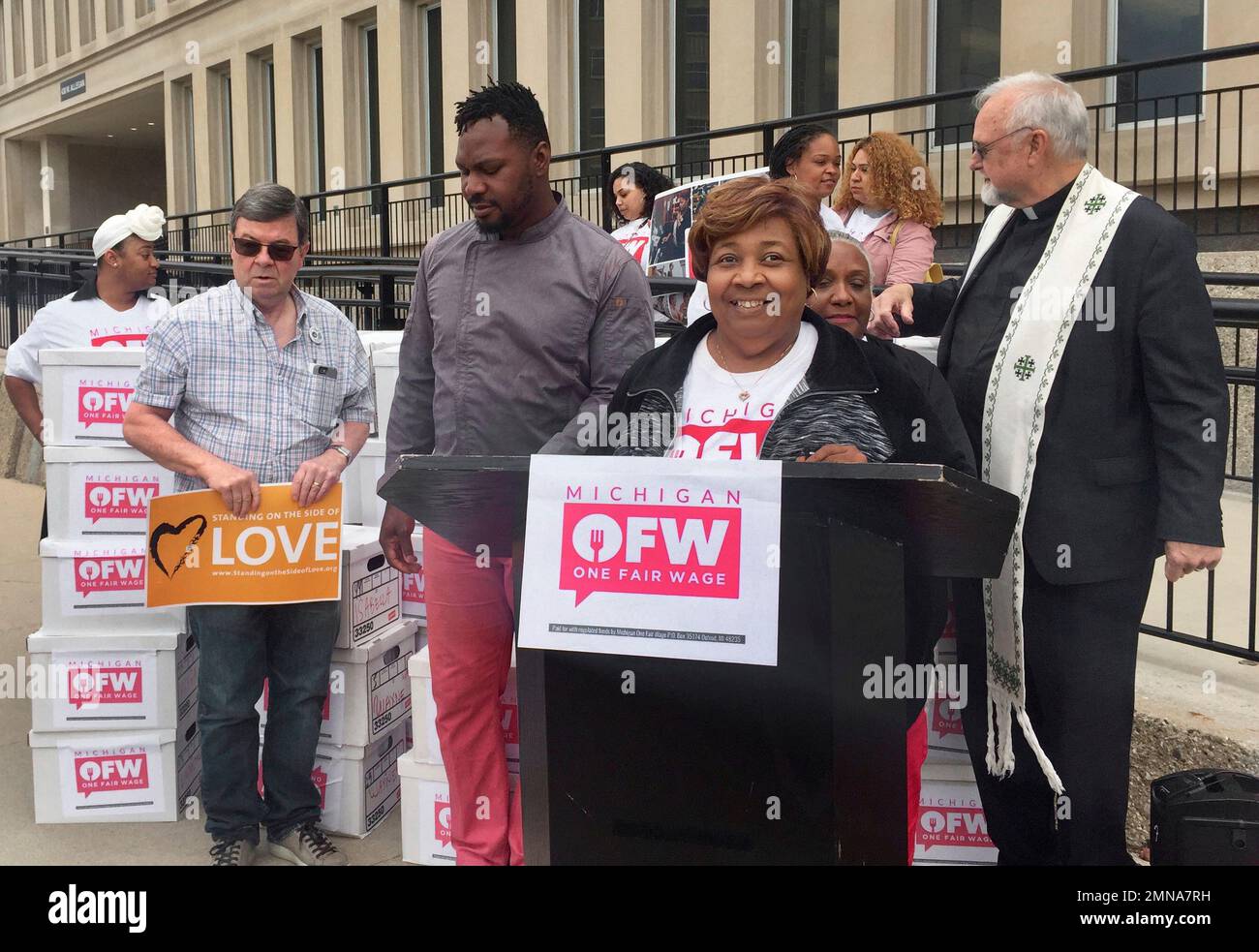 Alicia Renee Farris, front right, campaign chair of the Michigan One Fair  Wage group, speaks Monday, May 21, 2018, in support of raising Michigan's minimum  wage to $12 an hour in front