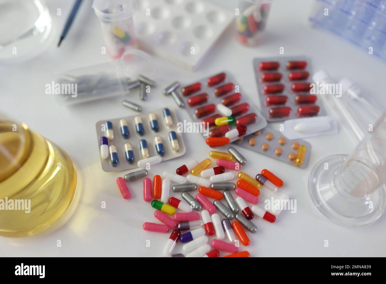 Many different medical pills and drugs with flasks on lab table, top view. Stock Photo