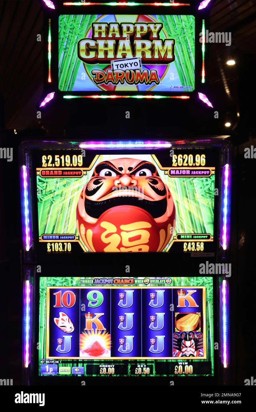 Illuminated slot machines with colourful graphics and flashing light sequences attract players by tempting them with the prospect of a quick payback. Stock Photo