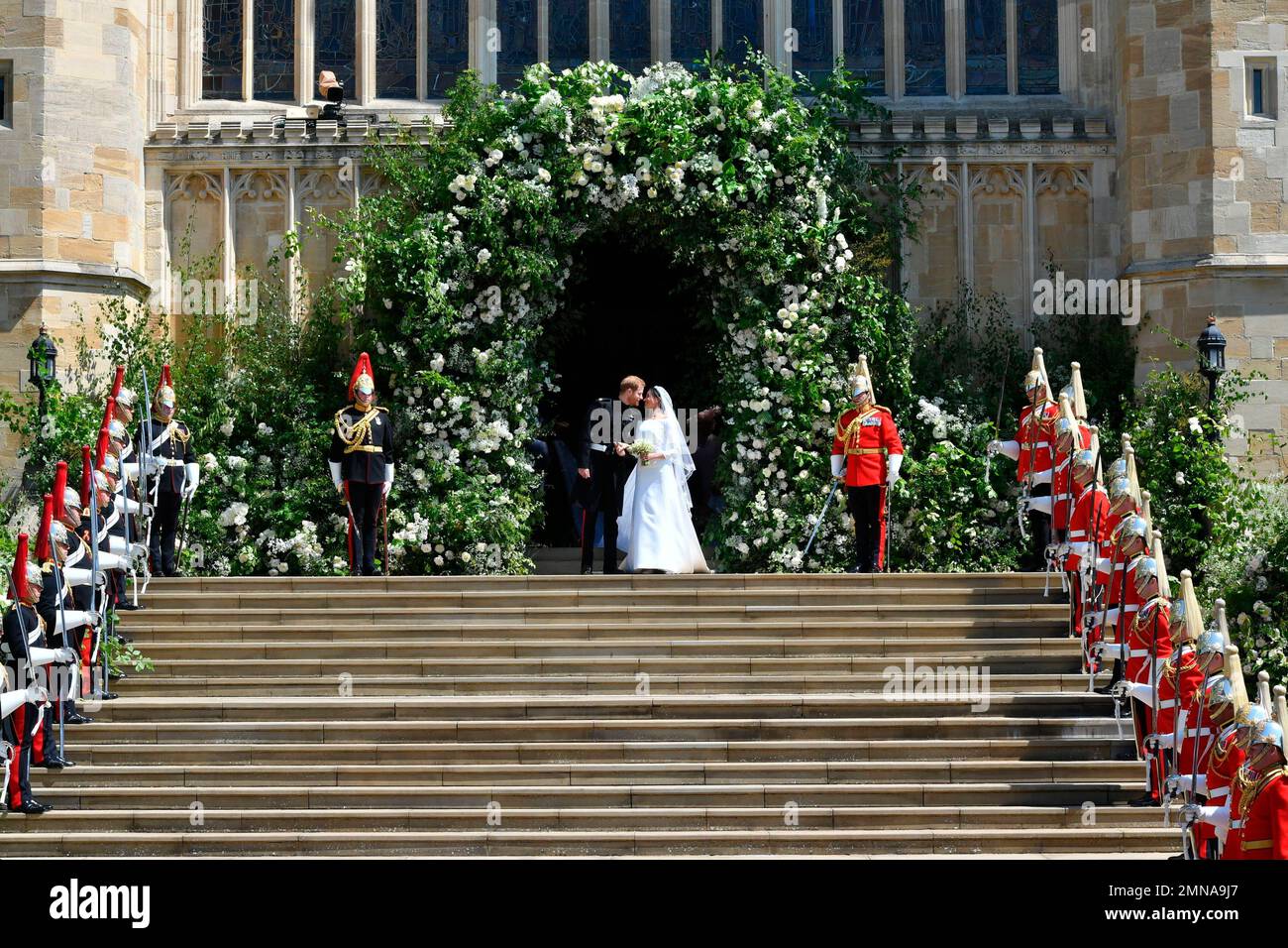 Prince Harry and Meghan Markle kiss on the steps of St. Chapel