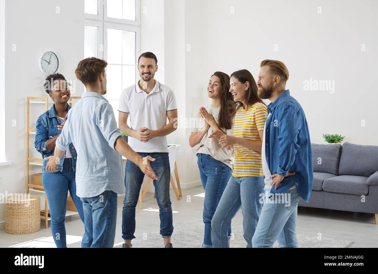 Joyful excited people listening interesting, exciting and funny story of their male friend. Stock Photo