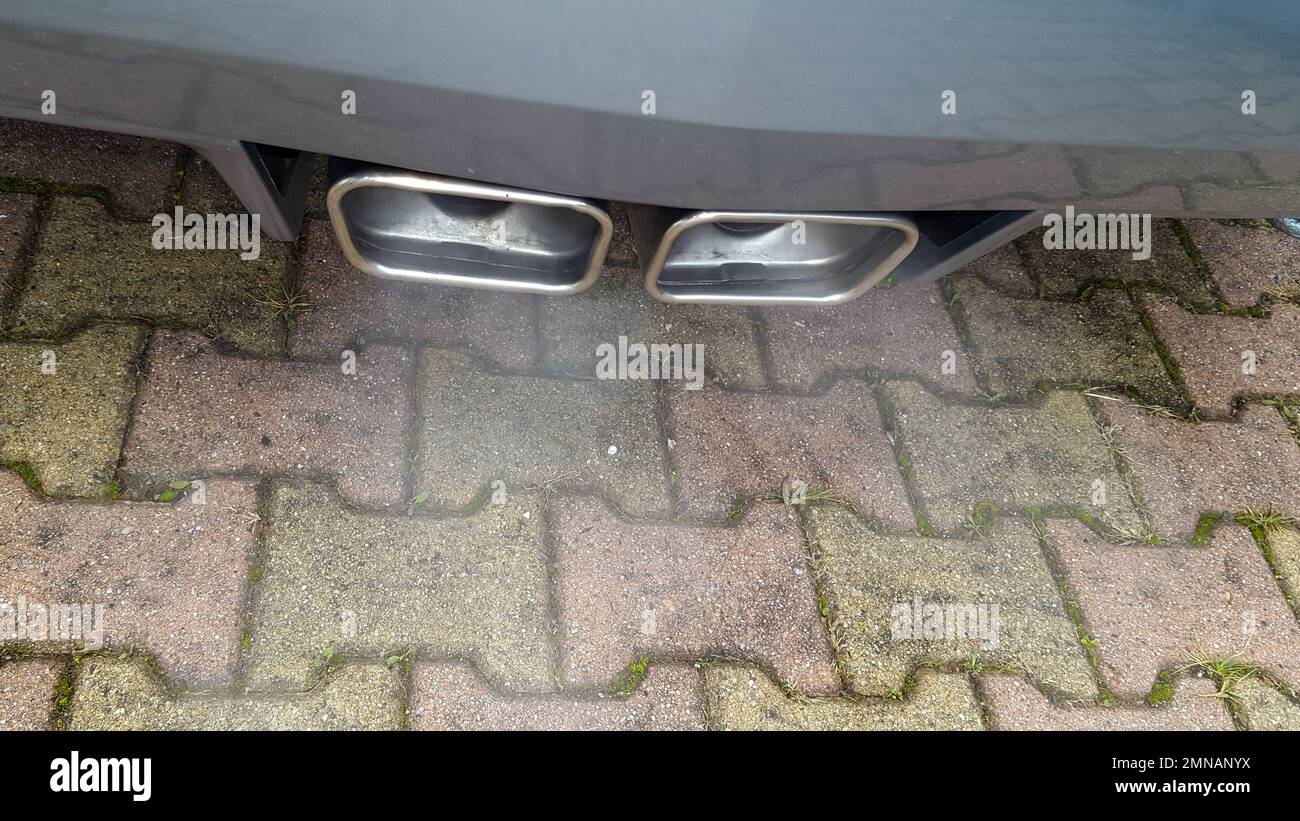 smoking grey sports car exhaust outlet in street Stock Photo Alamy