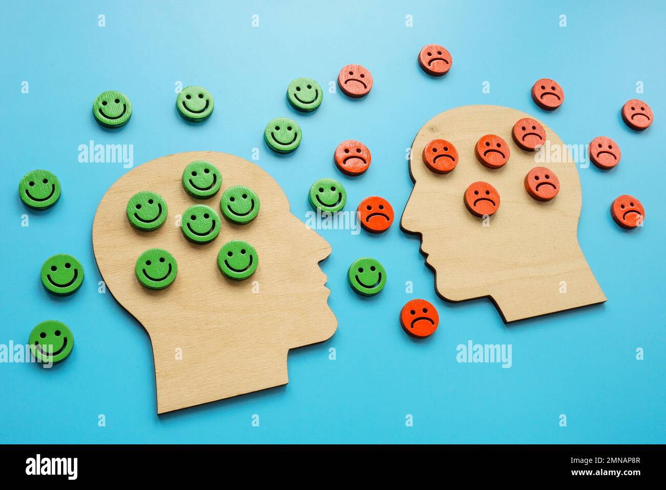 Heads with negative and positive emoticons. Resilience and emotions concept. Stock Photo