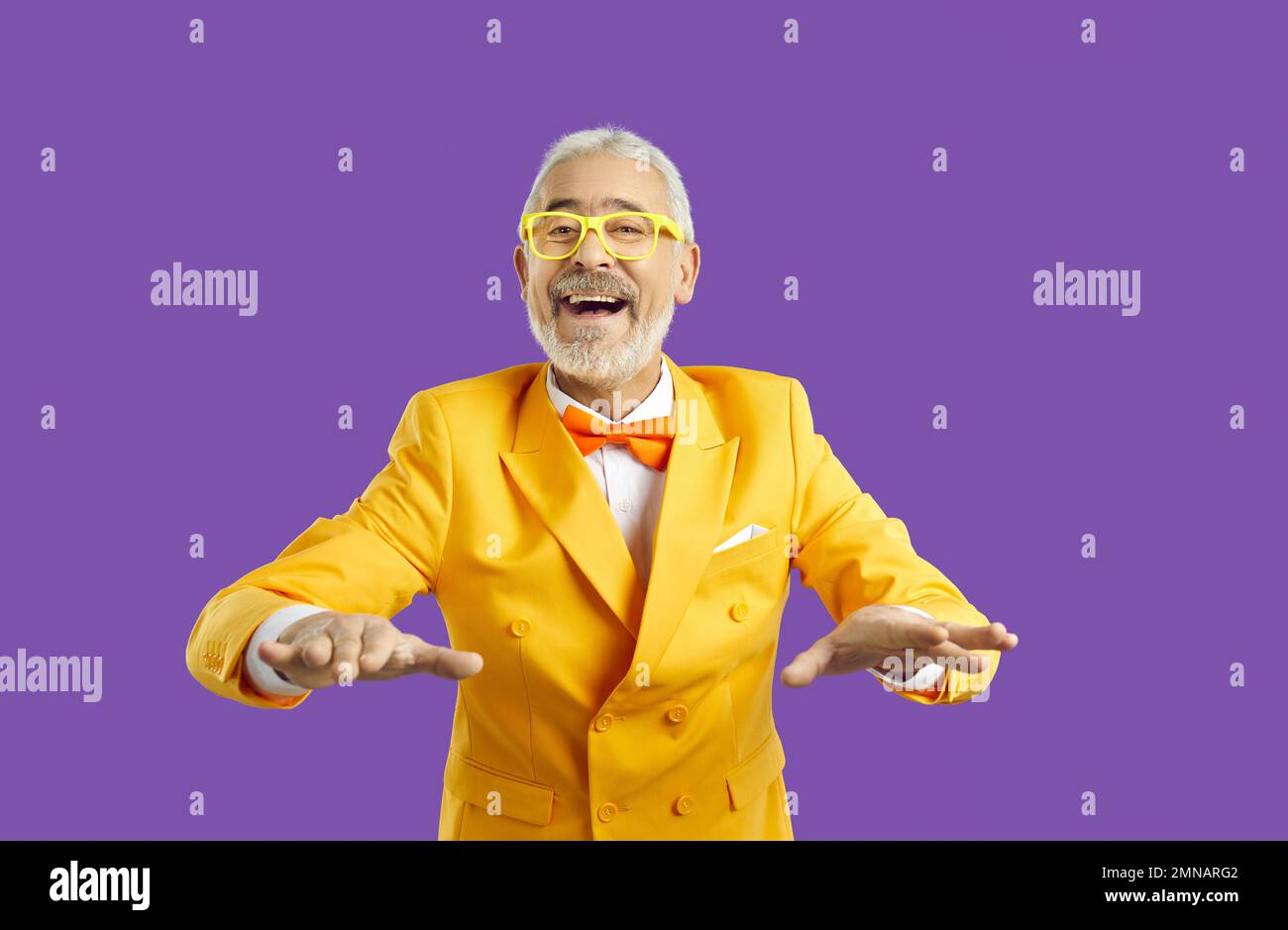 Funny senior man in suit on violet studio background Stock Photo