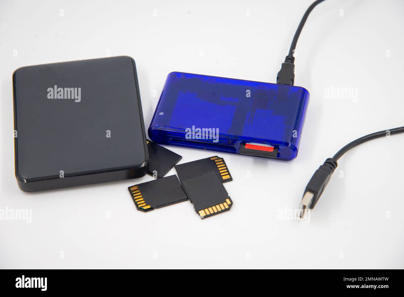 Black memory cards and external hard drive with blue card reader and