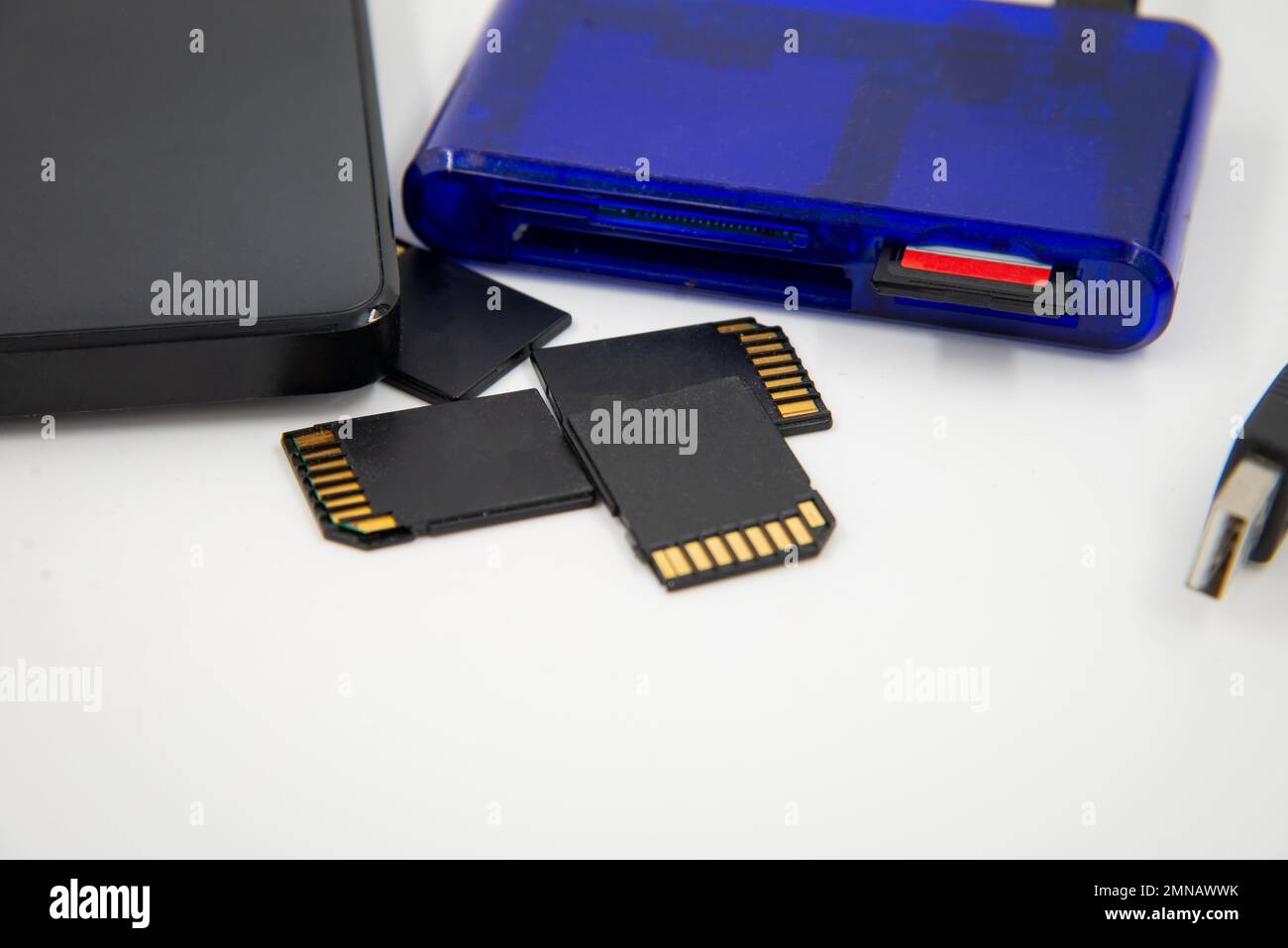 Black memory cards and external hard drive with blue card reader and