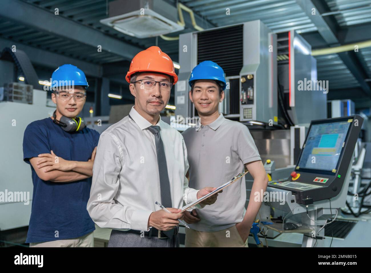 Three engineers working in the factory Stock Photo - Alamy