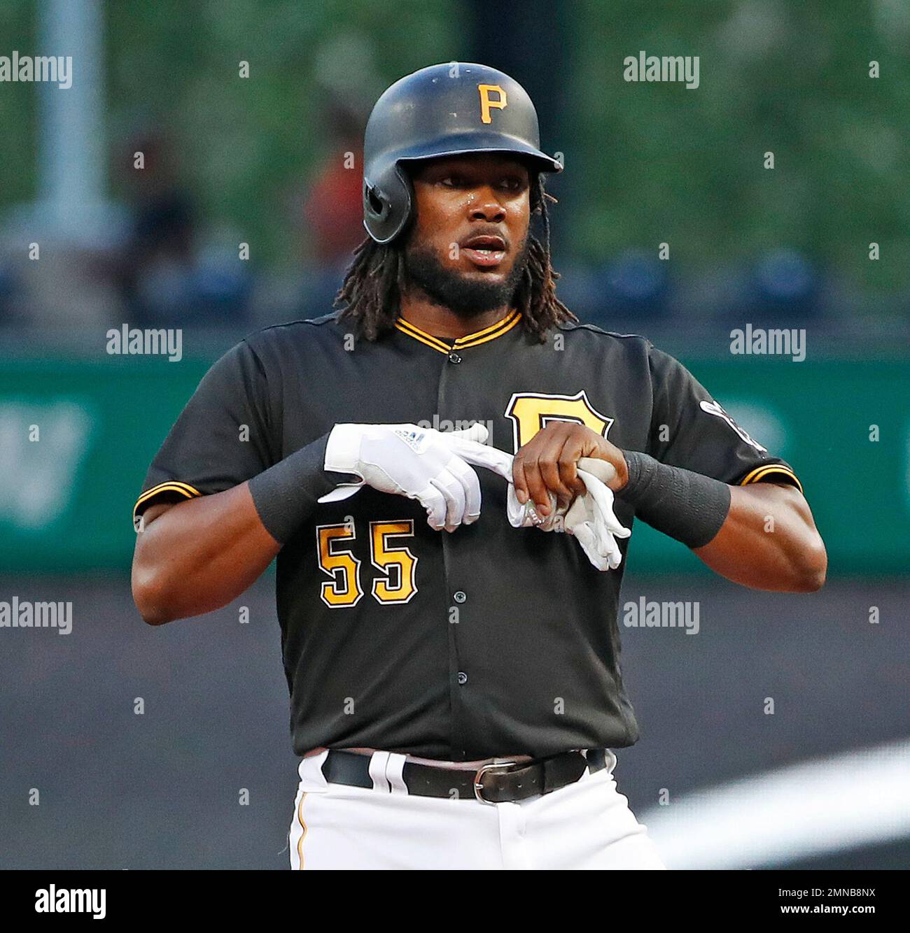 Pittsburgh Pirates' Josh Bell pulls off his batting gloves as he stands on  second base after driving in two runs with a double off Chicago White Sox  starting pitcher Reynaldo Lopez in