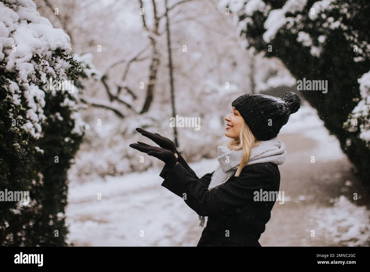 Pretty young woman n warm clothes enjoying in snow Stock Photo
