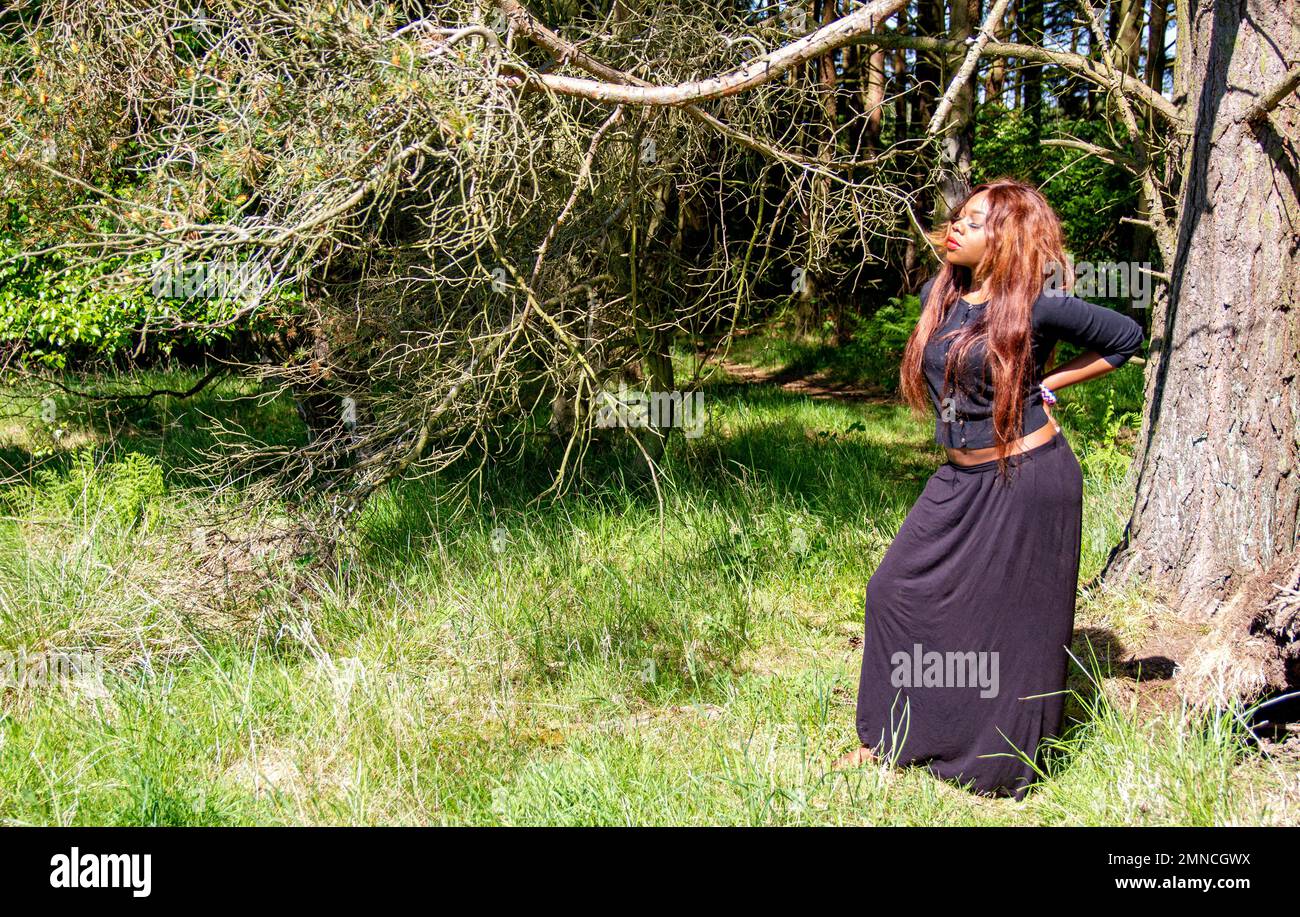 A beautiful African woman, enjoys a day out at Dundee's Clatto Country Park woods, UK Stock Photo