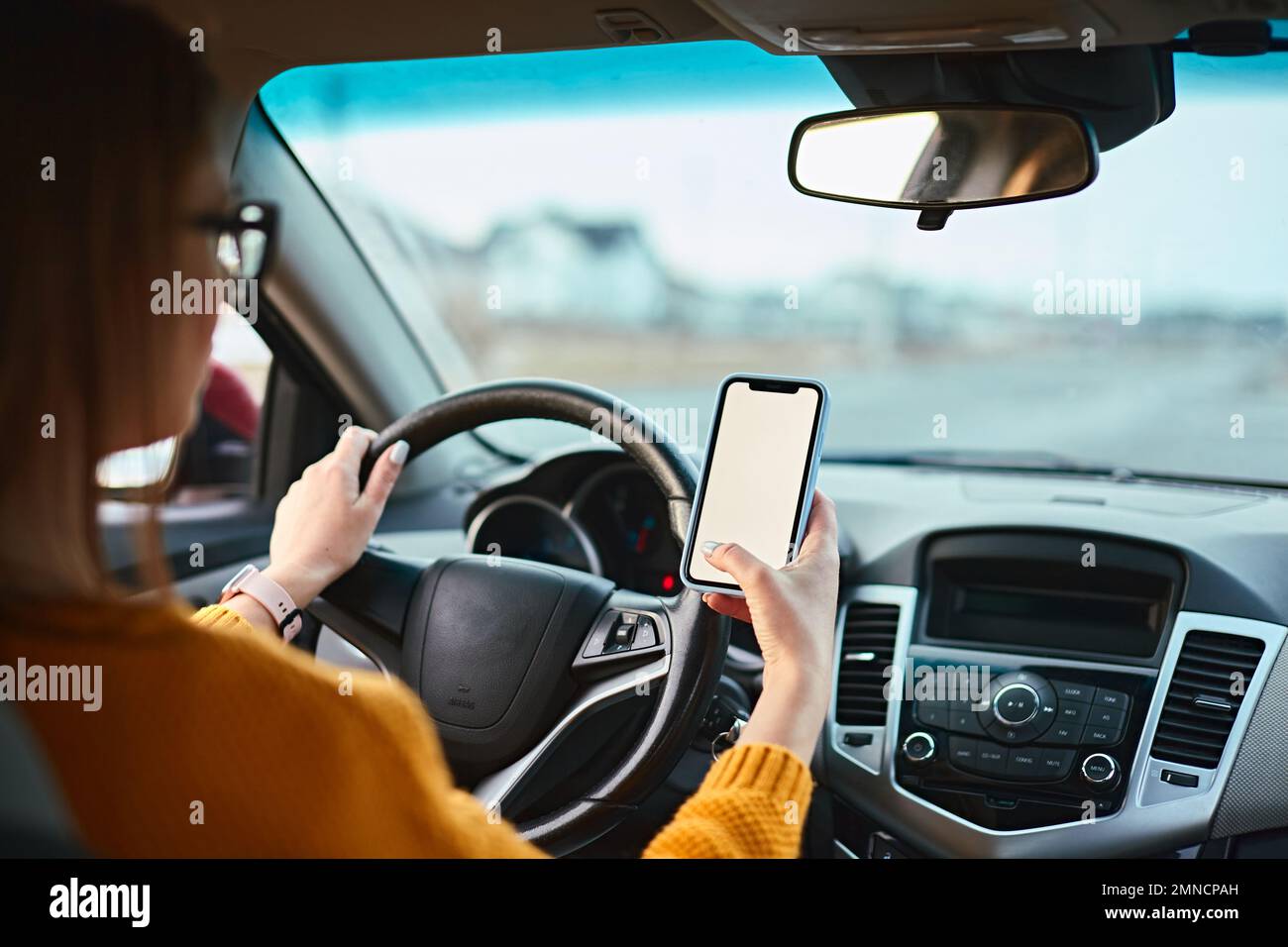 woman driver using mobile phone screen blank mockup on the road while