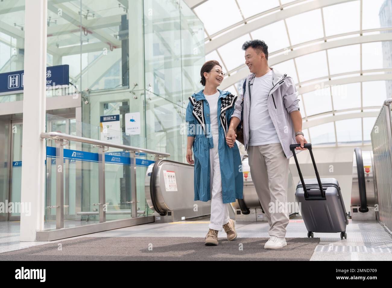 Happy elderly couple take the elevator at the airport Stock Photo - Alamy