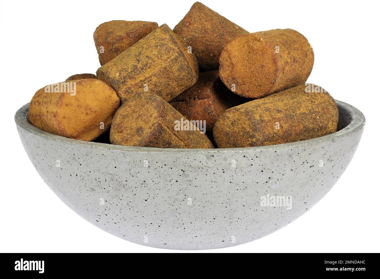 Dutch cinnamon candy sticks in a concrete bowl isolated on white background Stock Photo