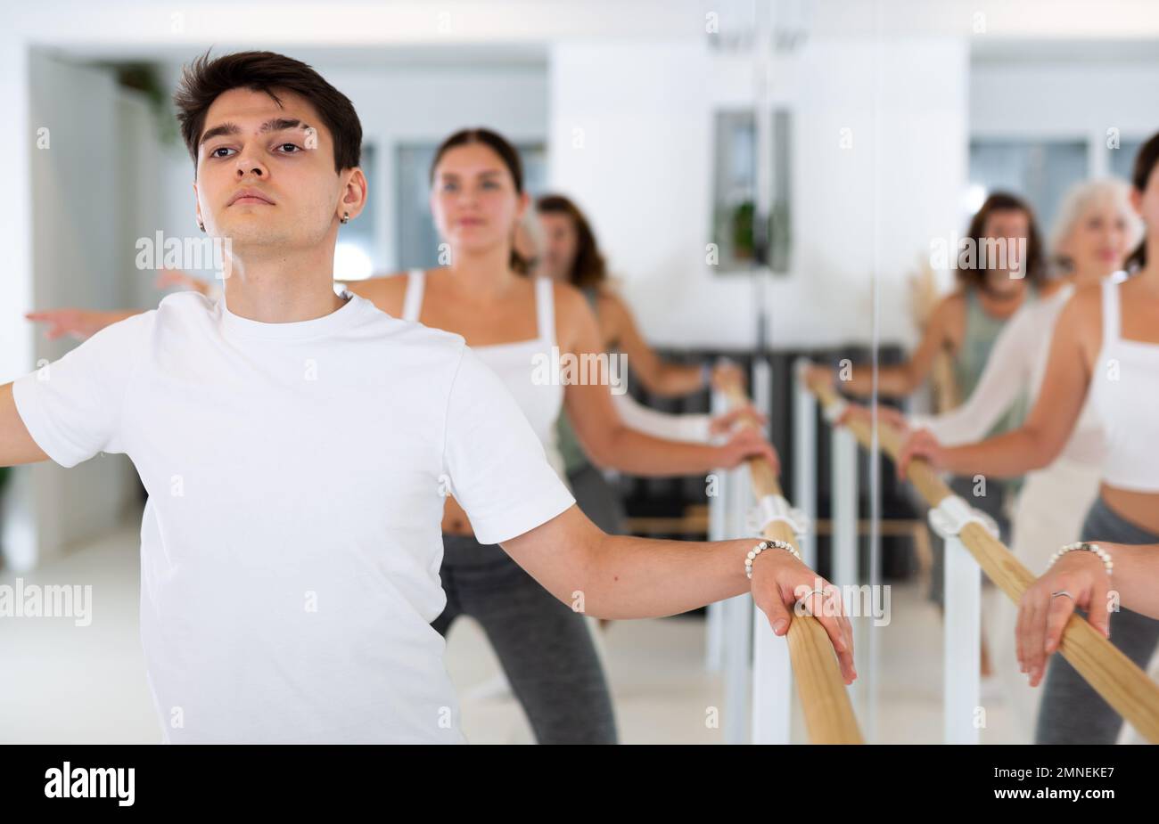 Diligent young man doing choreography at ballet barre Stock Photo