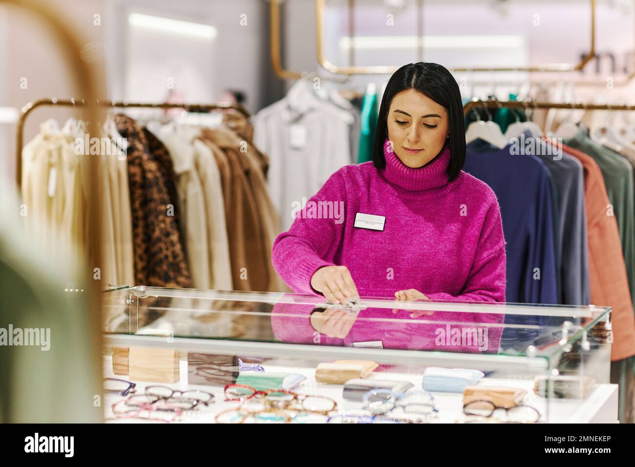 Waist up portrait of young woman wiping glass counter in luxury boutique while preparing shop for opening, copy space Stock Photo