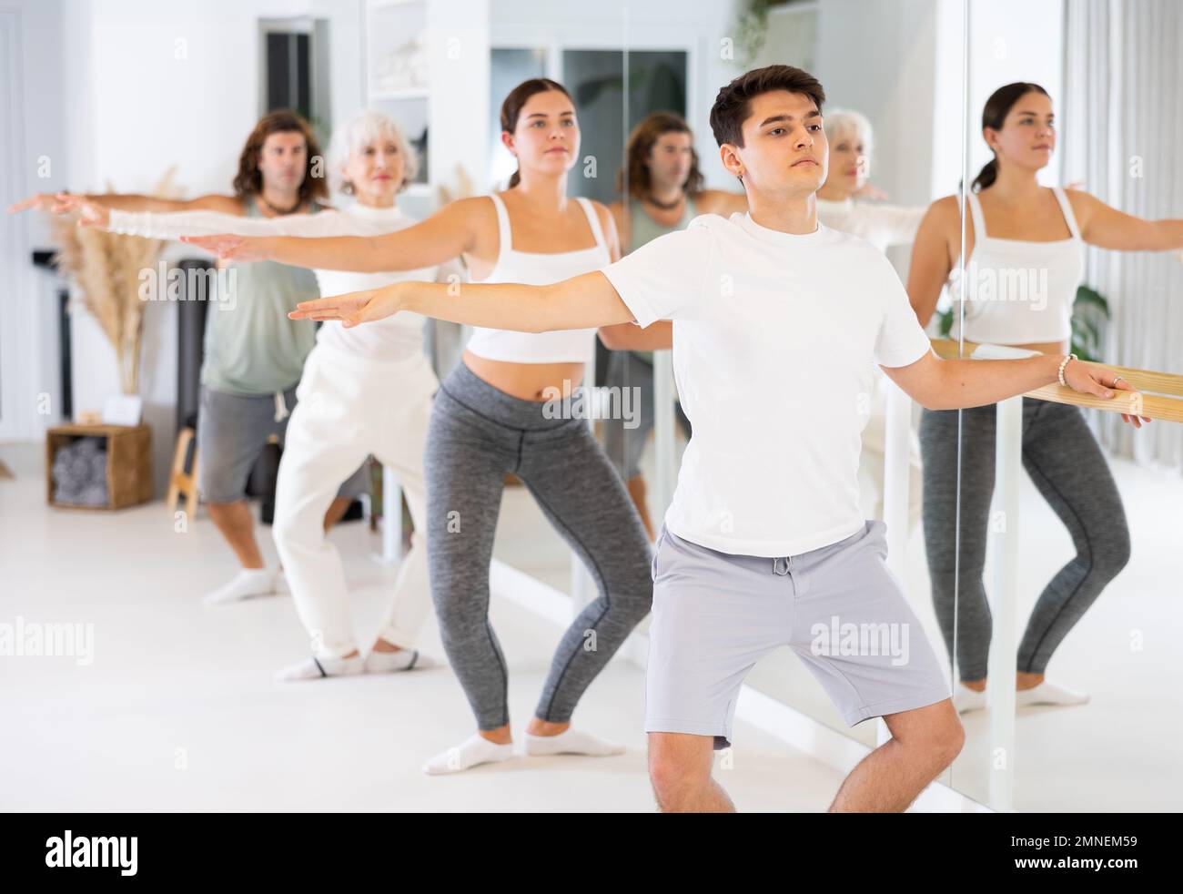 Diligent young man doing choreography at ballet barre Stock Photo