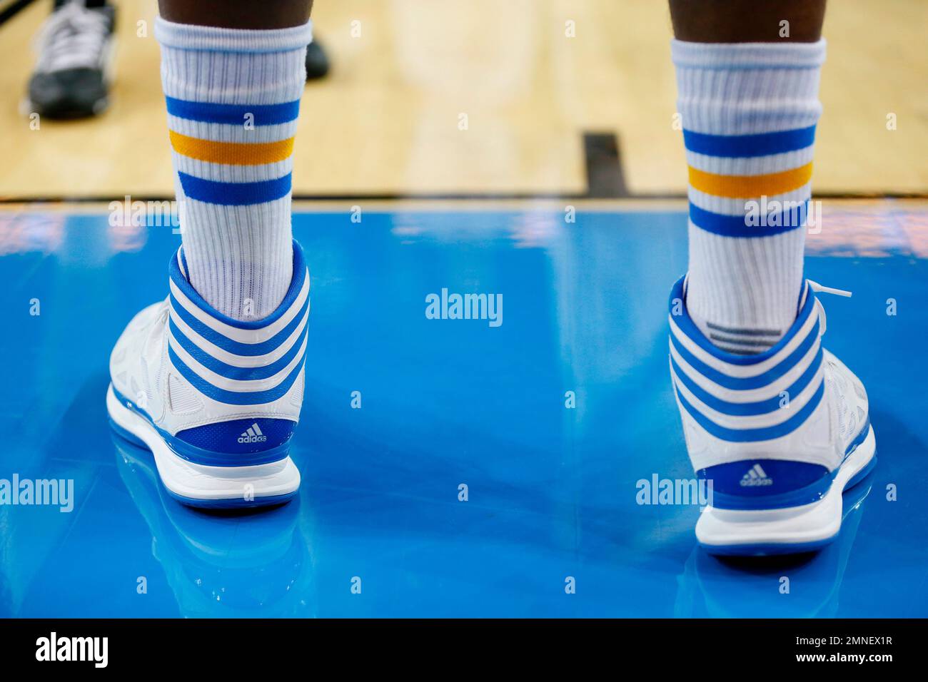 FILE - Adidas basketball shoes and socks are worn by a college basketball  player during the second half of an NCAA college basketball game in Los  Angeles. The Commission on College Basketball