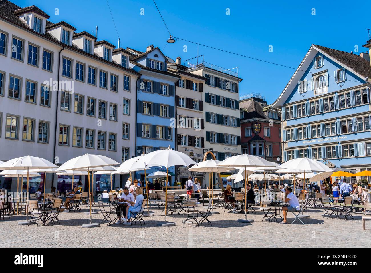 Tables and chairs on a square in the old town, historic houses at