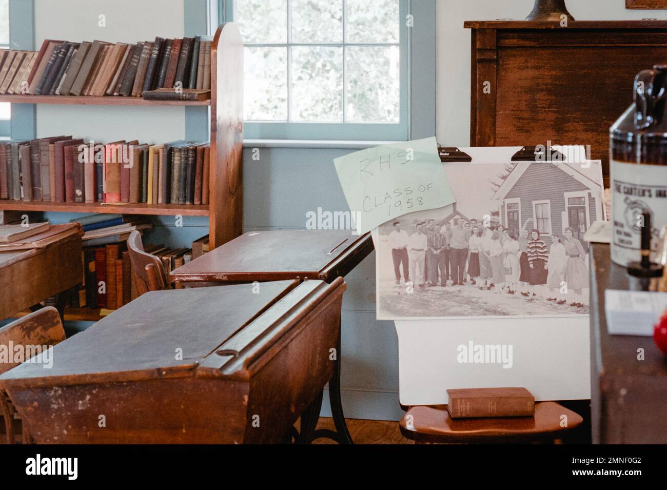 A vintage one room schoolhouse moved the location in Deerfield with a picture of the graduating class on 1958 hanging on a chair at the Deerfield Fair Stock Photo