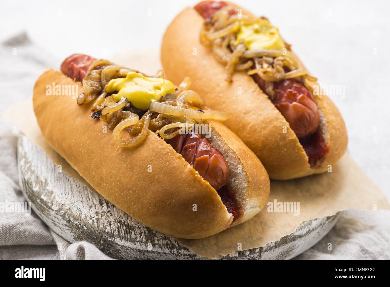 Gourmet dirty hot dog sandwich with various garnish on black slate