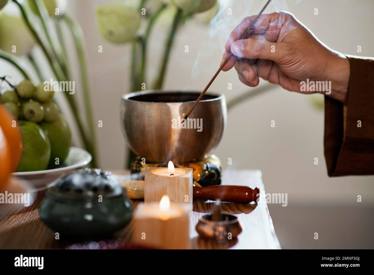 side view man lighting incense stick. High resolution photo Stock Photo