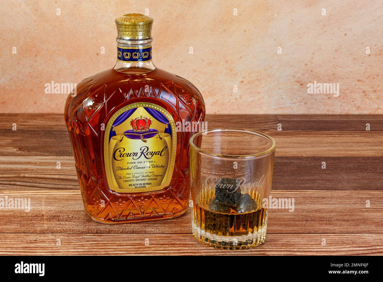 Flourtown, PA - Jan. 22, 2023: Crown Royal Blended Canadian Whisky bottle and glass with a drink over whiskey stones. Stock Photo
