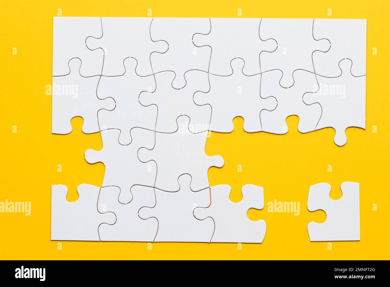 white cardboard jigsaw puzzles yellow background. High resolution photo