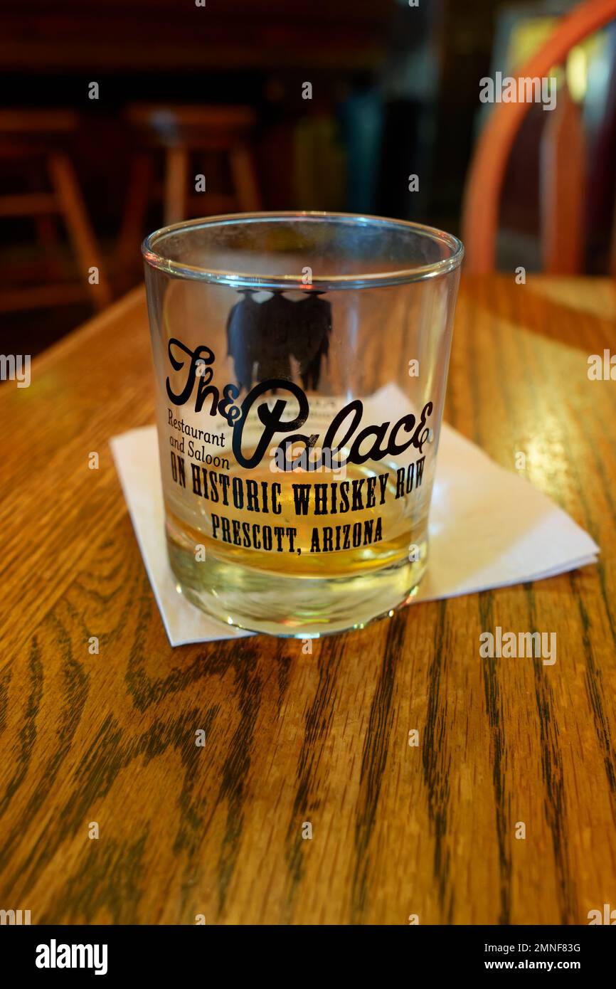 Prescott, AZ - Nov. 17, 2022: Soft focus on a glass with a shot of whiskey sitting on a table in The Palace Restaurant and Saloon on Historic Whiskey Stock Photo