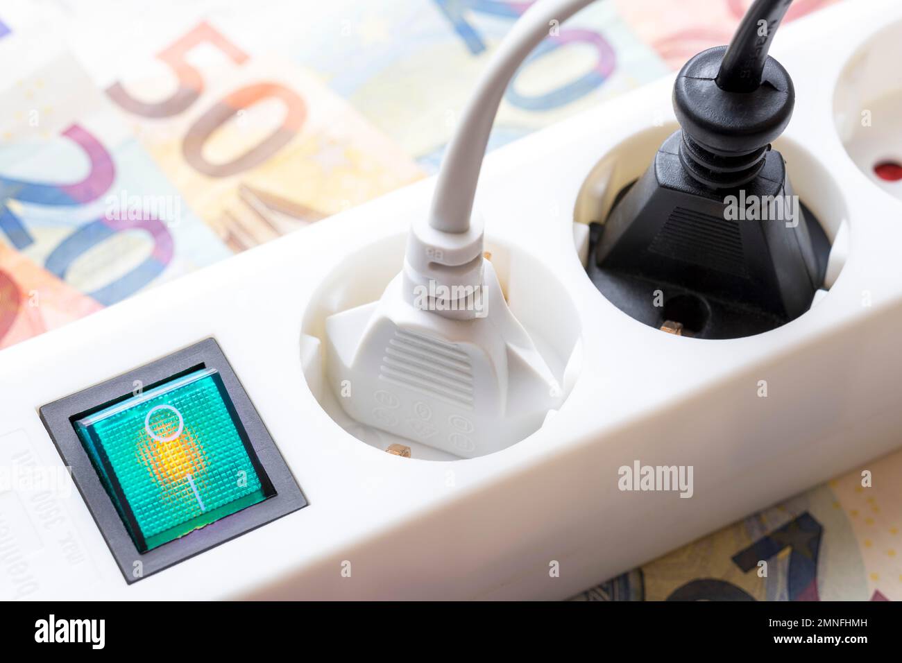 Incidental costs electricity, symbolic image, power strip with switch, plugged-in plugs, banknotes, Germany Stock Photo