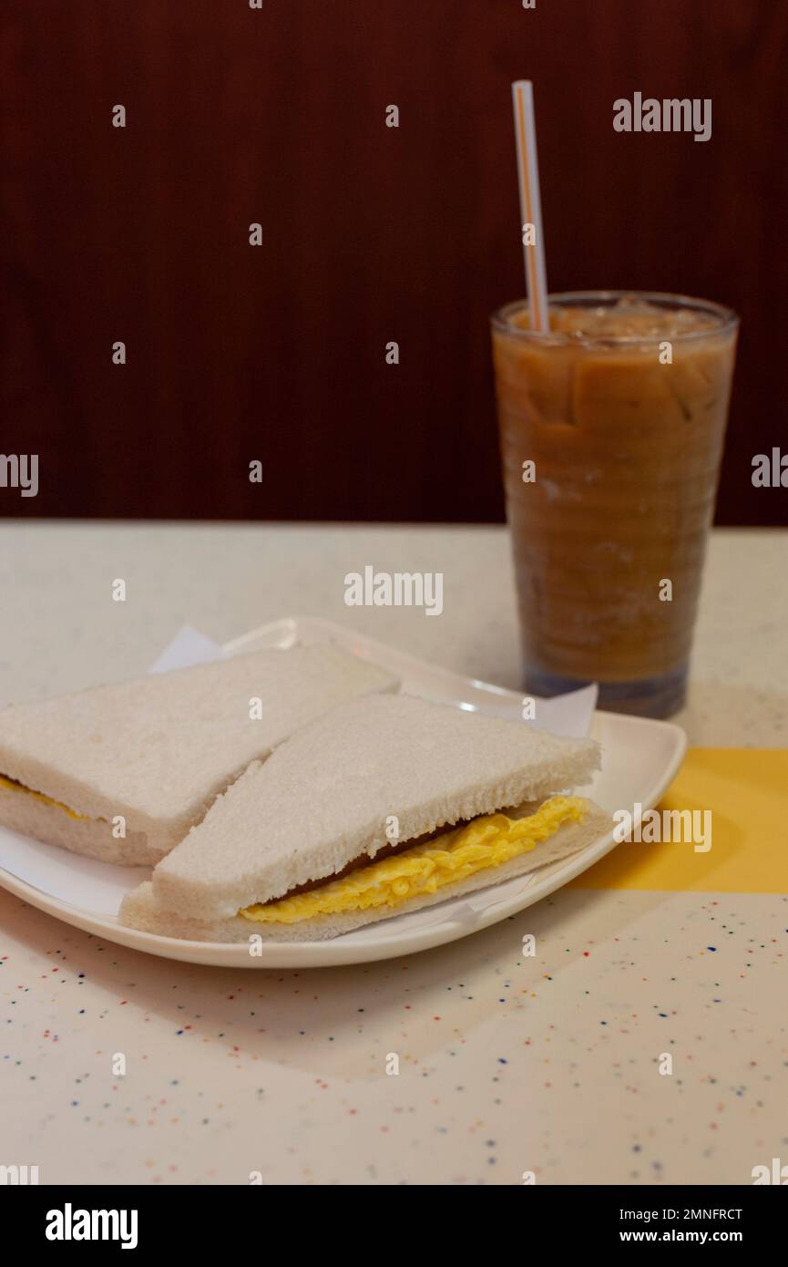 An egg sandwich and iced milk tea served at a traditional Cha chaan