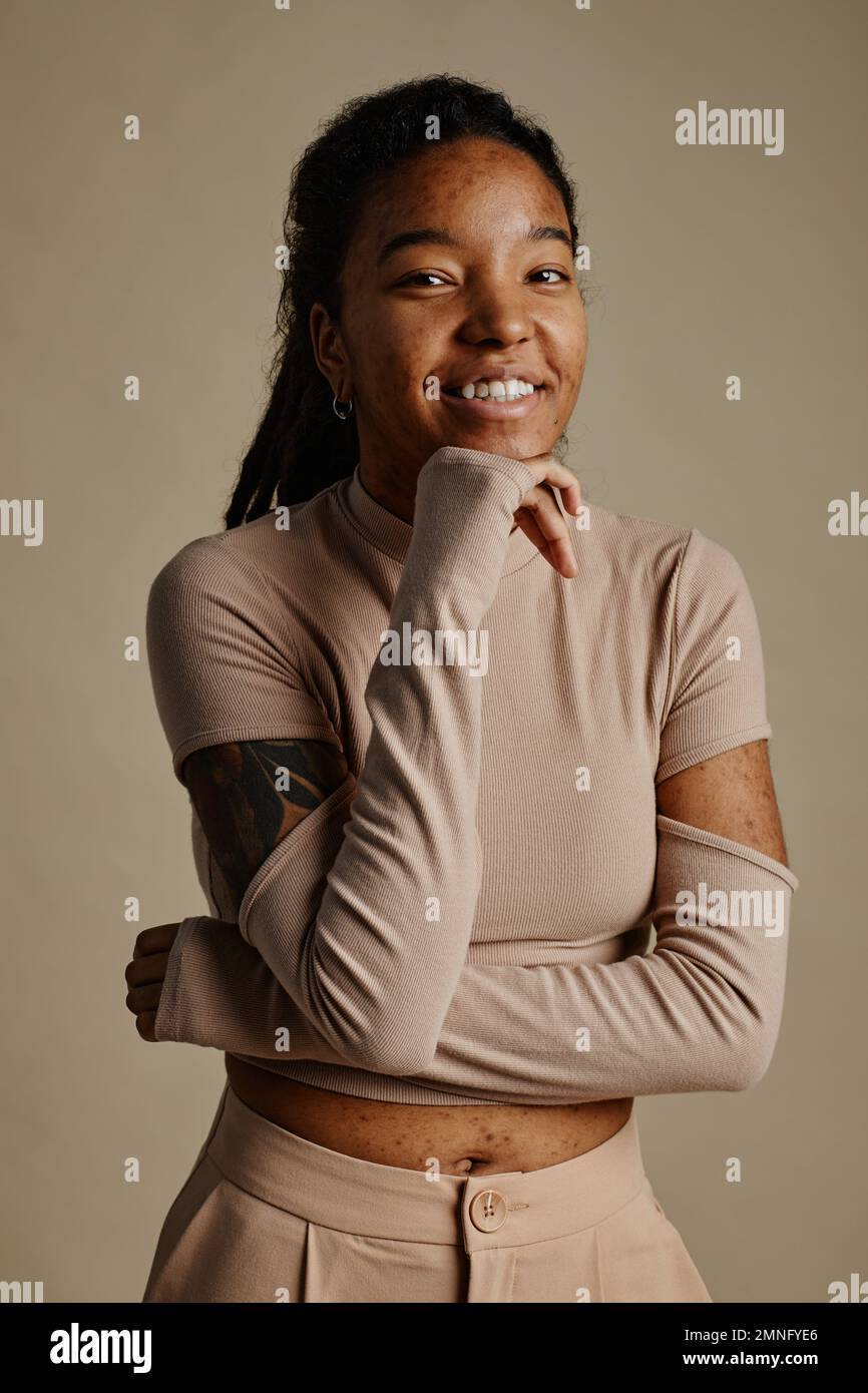 Vertical waist up portrait of young black woman smiling genuinely and ...