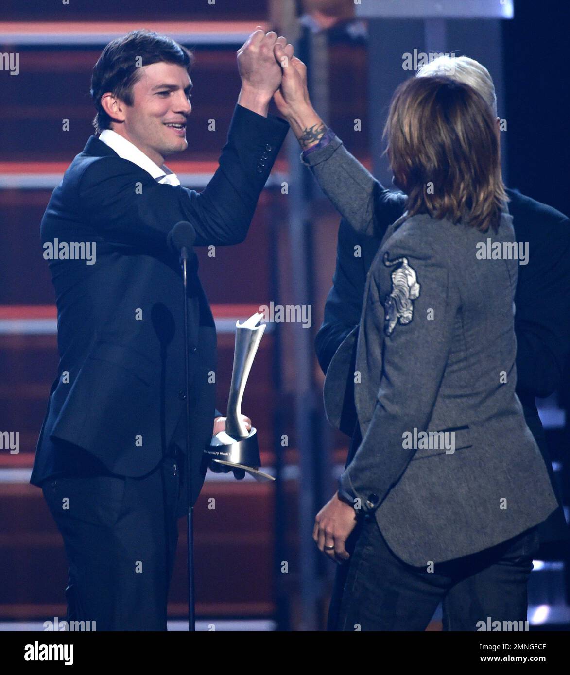 Ashton Kutcher, left, presents Keith Urban with the award for vocal
