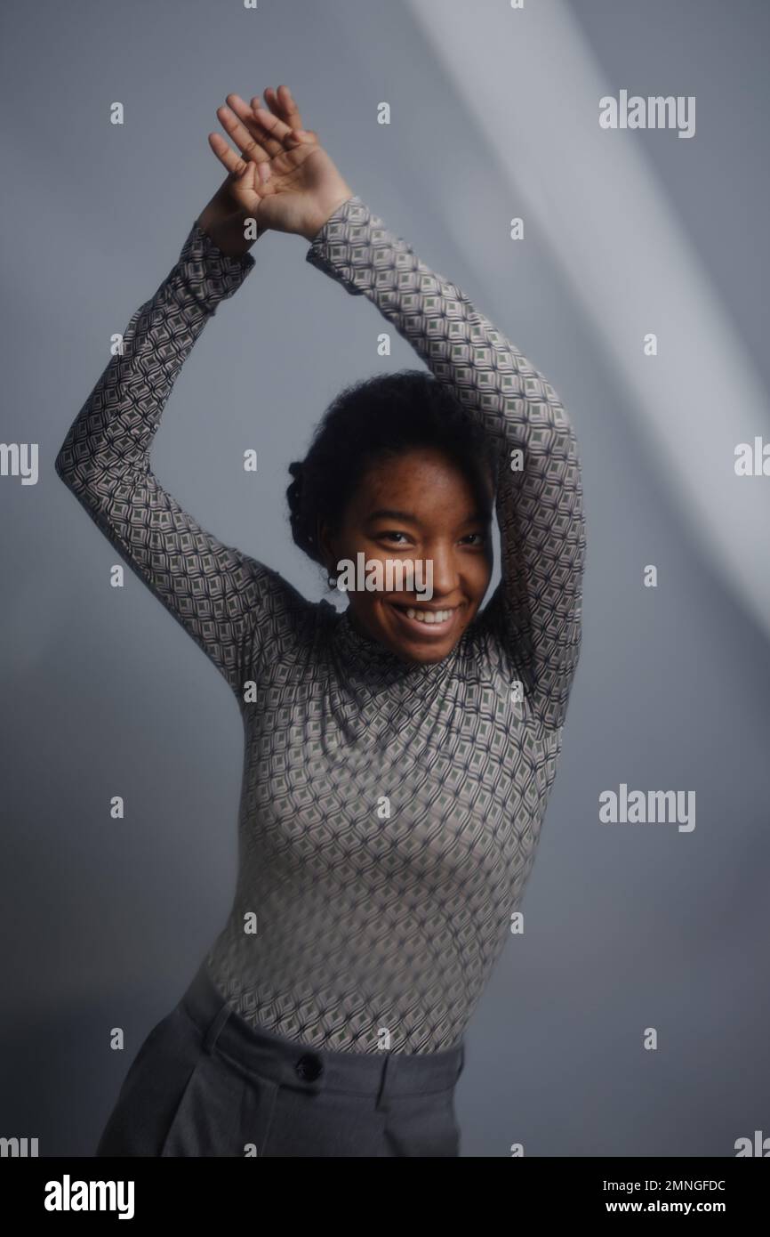 Minimal Portrait Of Smiling Black Woman Looking At Camera And Dancing