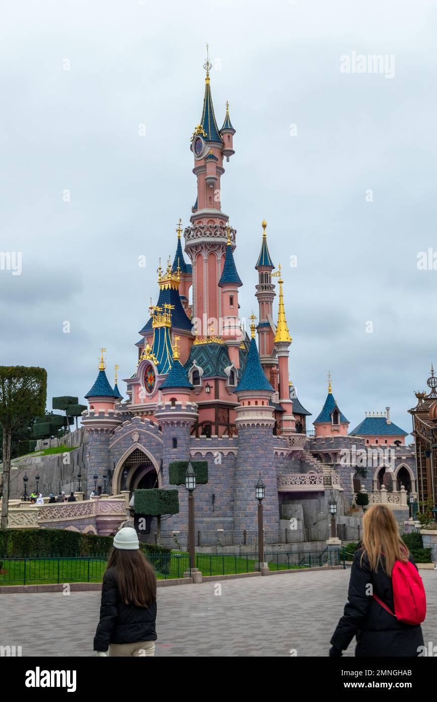 Disneyland Paris Castle the Sleeping Beauty Castle. Fantasyland at Disneyland Park. Blonde women with Red backpack at Disneyland park. Stock Photo