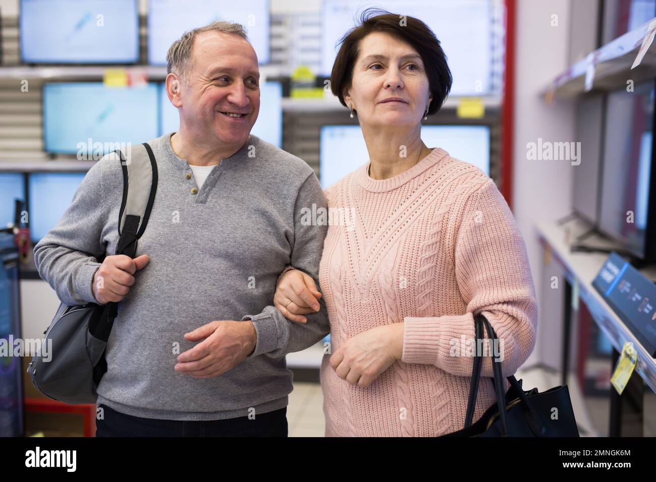 Senior couple picking new TV in tech store Stock Photo