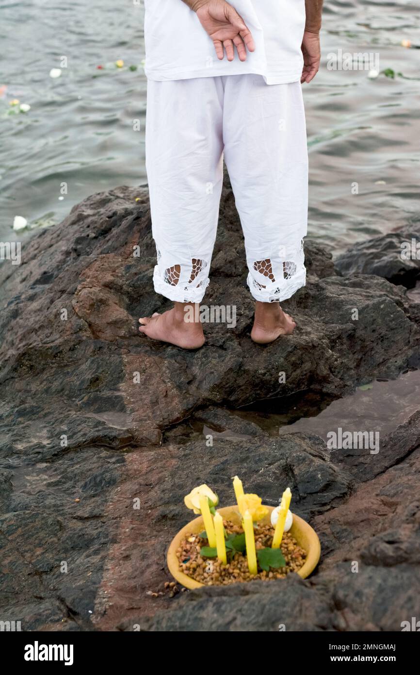 Salvador, Bahia, Brazil - February 02, 2017: Candomble admirers are seen on top of a rock on the beach, paying homage to Iemanja with gifts on the day Stock Photo