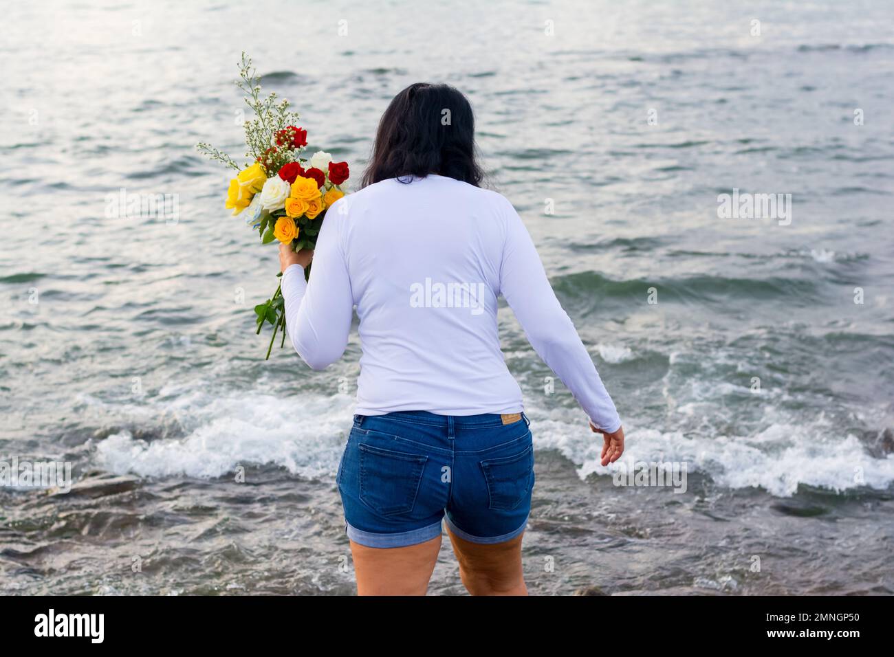 Salvador, Bahia, Brazil - February 02, 2017: Faithful Candomble women deliver flowers to the sea on the day of the feast in honor of Iemanja. Salvador Stock Photo