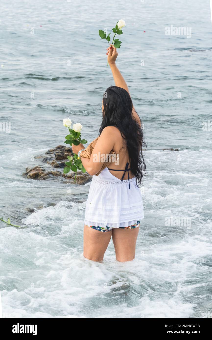 Salvador, Bahia, Brazil - February 02, 2017: Faithful Candomble women deliver flowers to the sea on the day of the feast in honor of Iemanja. Salvador Stock Photo