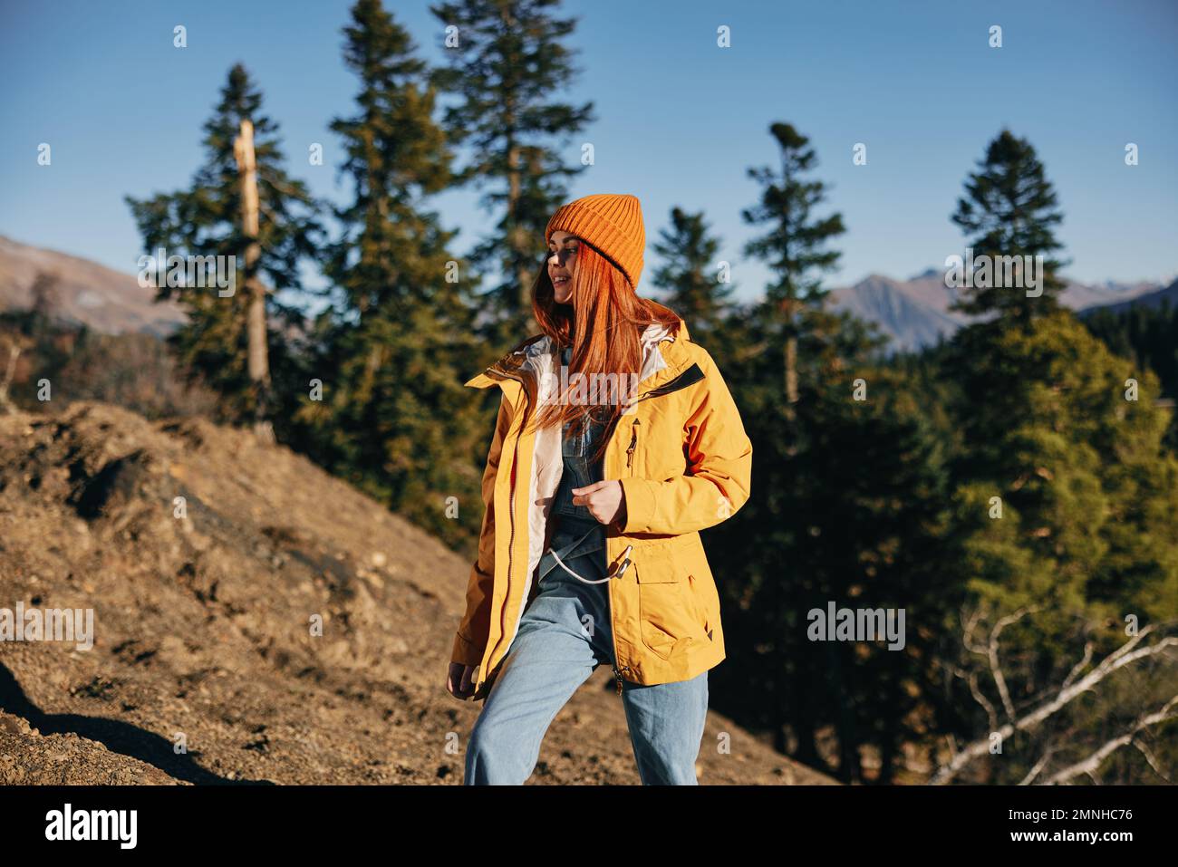 Woman hiking in the mountains in the autumn, a smile and happiness in a ...