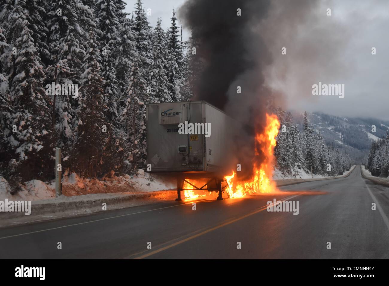Black smoke billows from a burning tractor trailor on the Trans-Canada highway Stock Photo