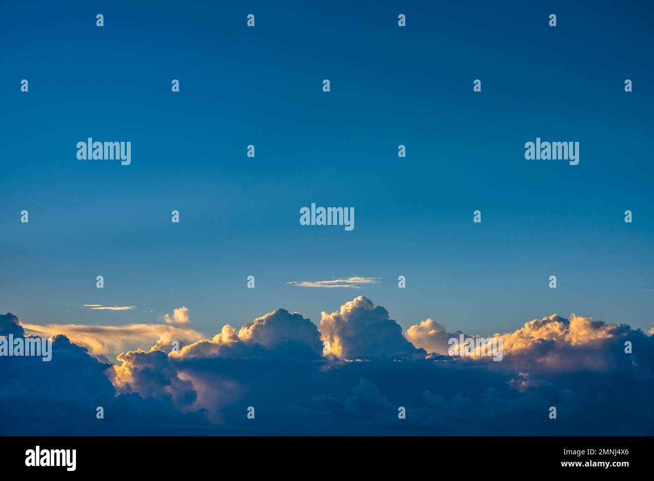Cumulus clouds on blue sky at sunrise Stock Photo