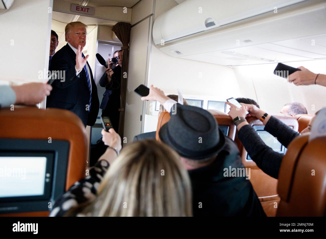 President Donald Trump talks with reporters aboard Air Force One on a ...